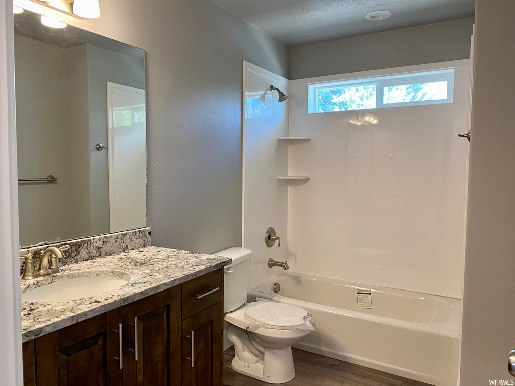 Full bathroom featuring plenty of natural light, toilet, bathtub / shower combination, mirror, and vanity