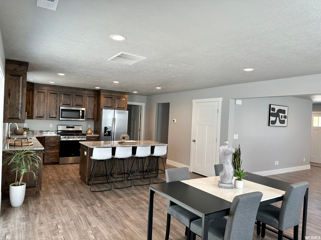 Hardwood floored dining space with a textured ceiling