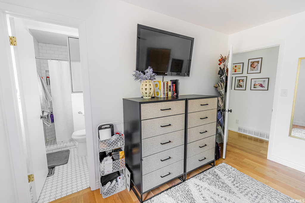 Bedroom featuring hardwood floors and TV