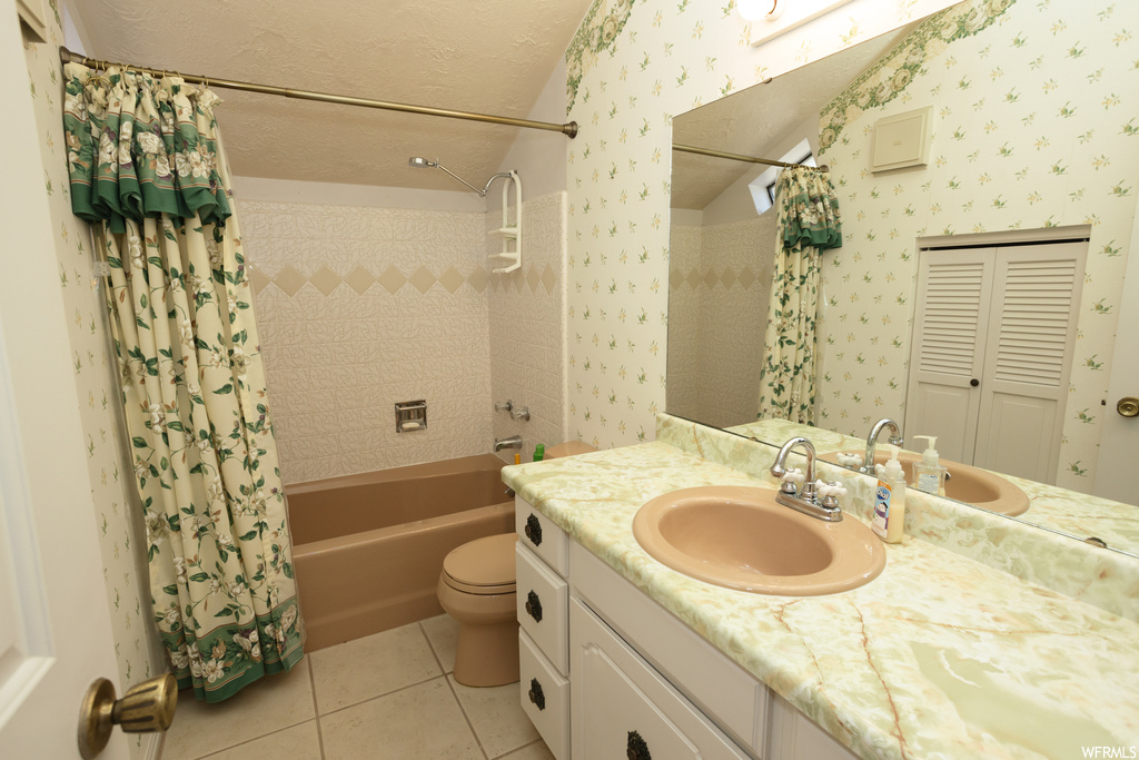 Full bathroom with tile floors, bathtub / shower combination, mirror, vanity, toilet, and shower curtain