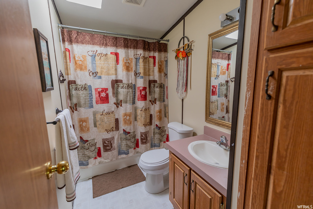 Bathroom featuring toilet, vanity, shower curtain, and multiple mirrors