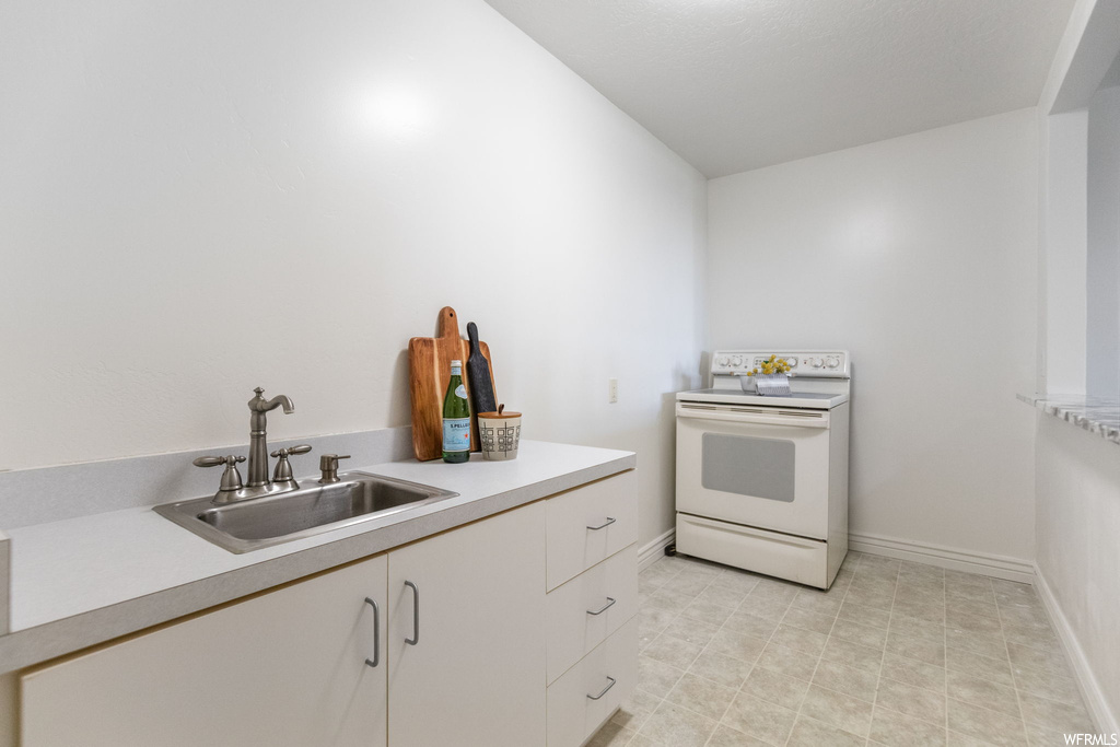 Kitchen featuring light tile floors, light countertops, and white range