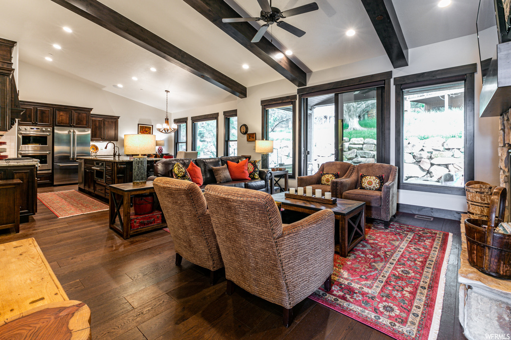 Living room featuring hardwood floors, wood beam ceiling, and natural light
