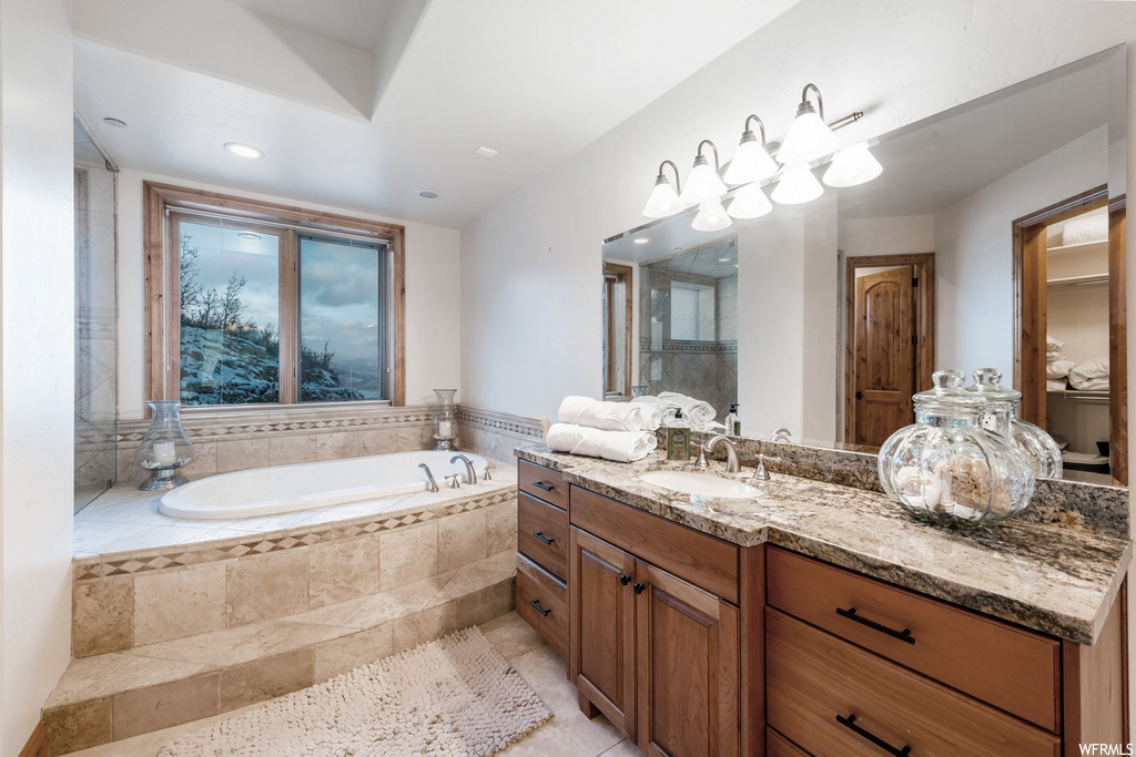 Bathroom featuring natural light, a bath, mirror, and large vanity