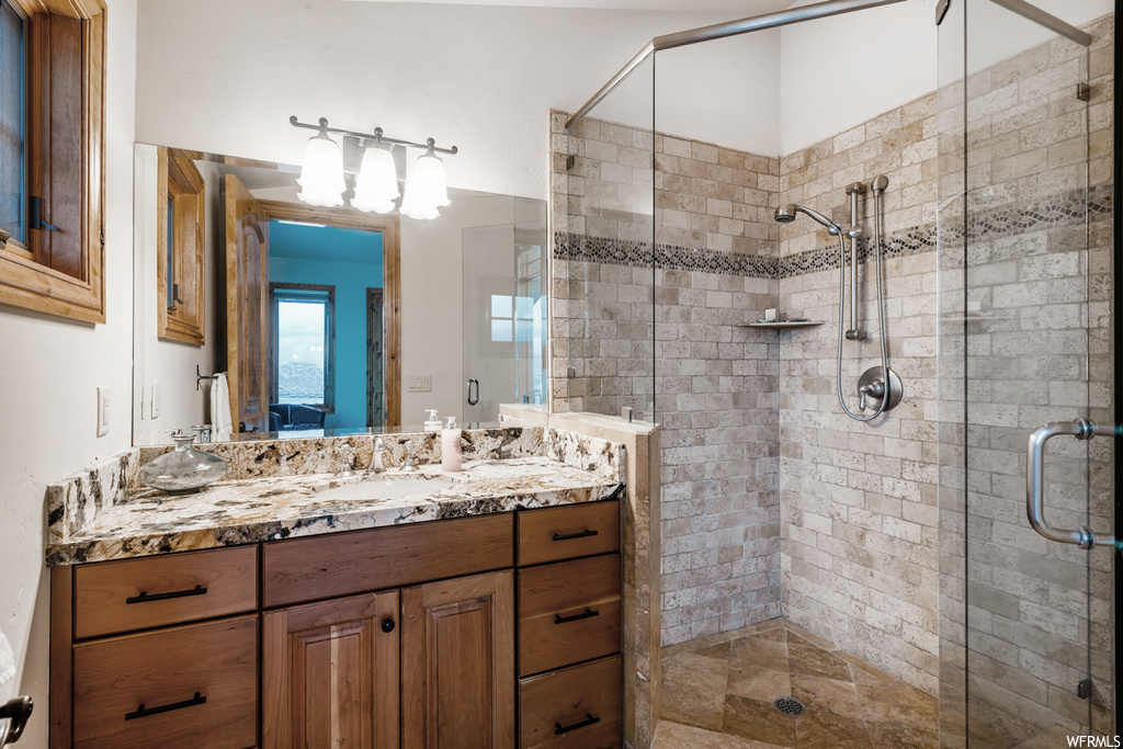 Bathroom with oversized vanity, shower with shower door, and mirror