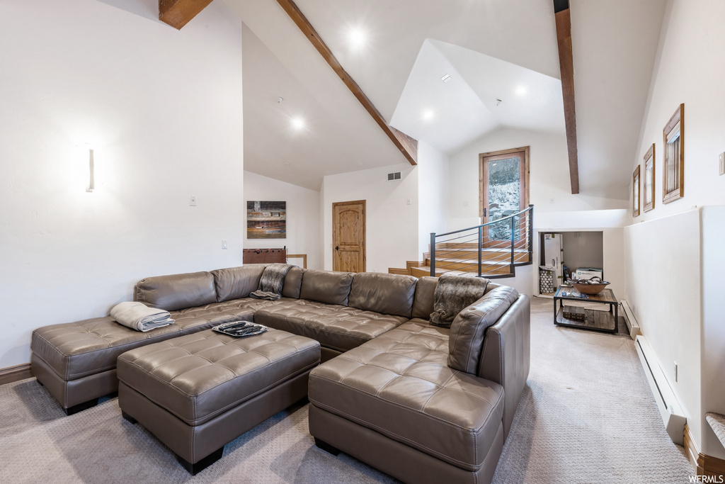 Living room featuring vaulted ceiling with beams and carpet