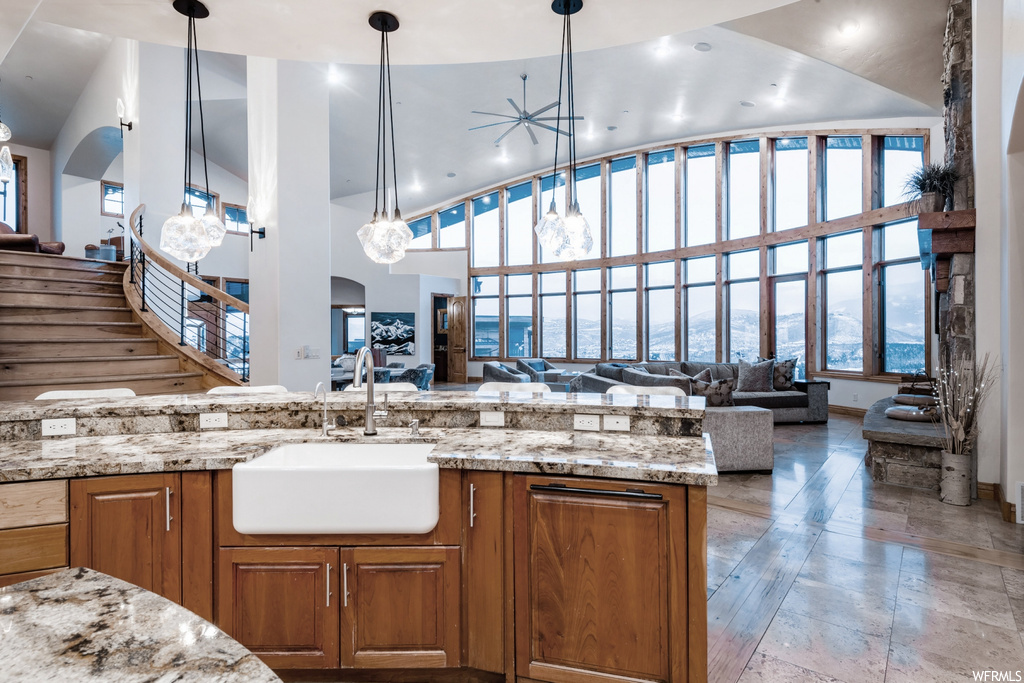 Kitchen featuring light granite-like countertops, light floors, and pendant lighting