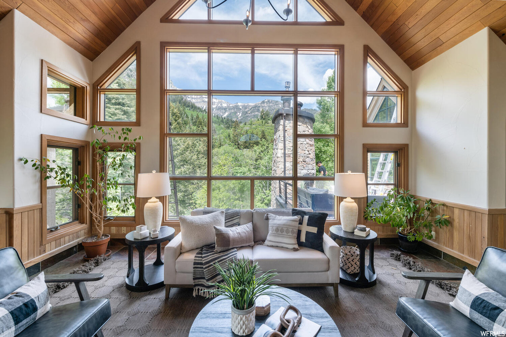 Living room with vaulted ceiling, a high ceiling, and natural light