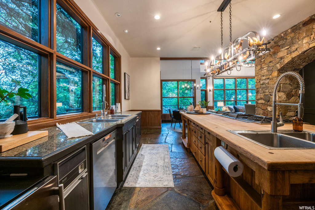 Kitchen with tile floors, natural light, a notable chandelier, and dishwasher