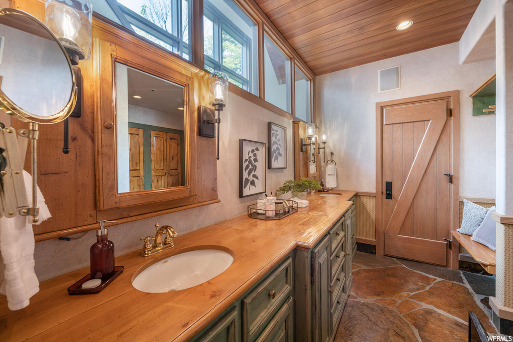 Bathroom with tile flooring, natural light, vanity with extensive cabinet space, and mirror