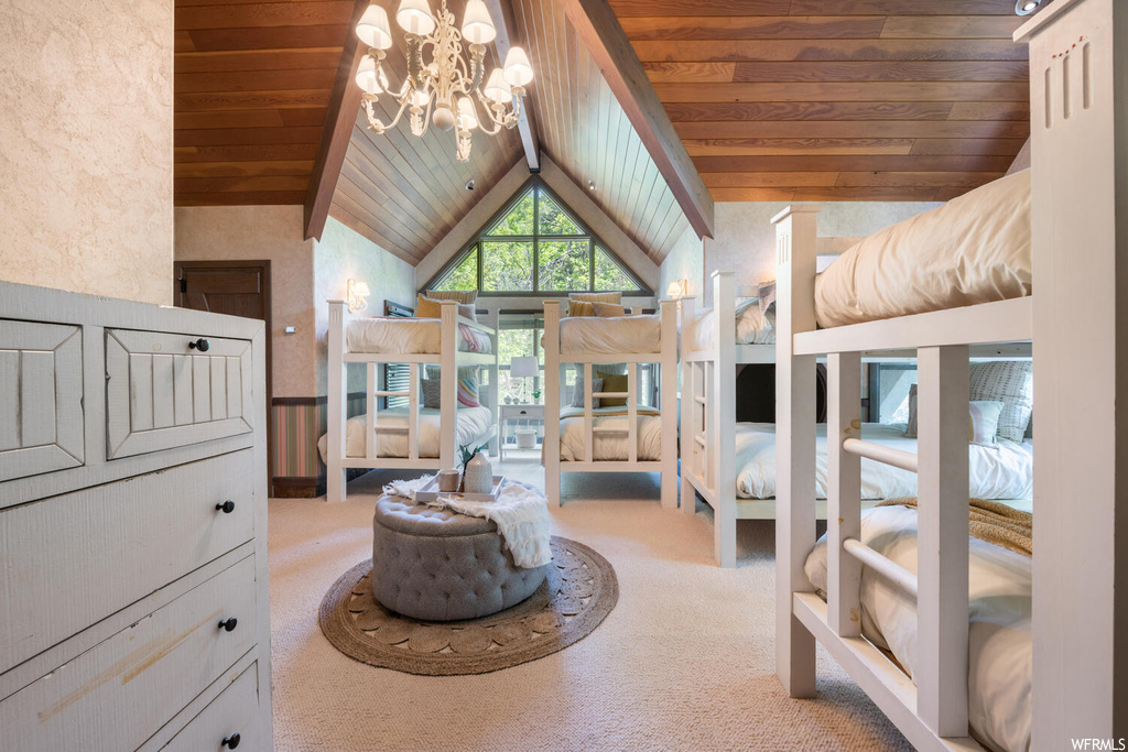 Bedroom with lofted ceiling, a high ceiling, carpet, a notable chandelier, and natural light
