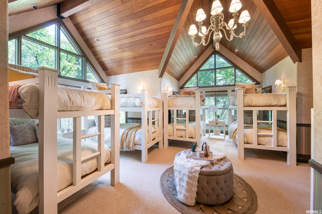 Bedroom with multiple windows, carpet, a notable chandelier, and lofted ceiling with beams