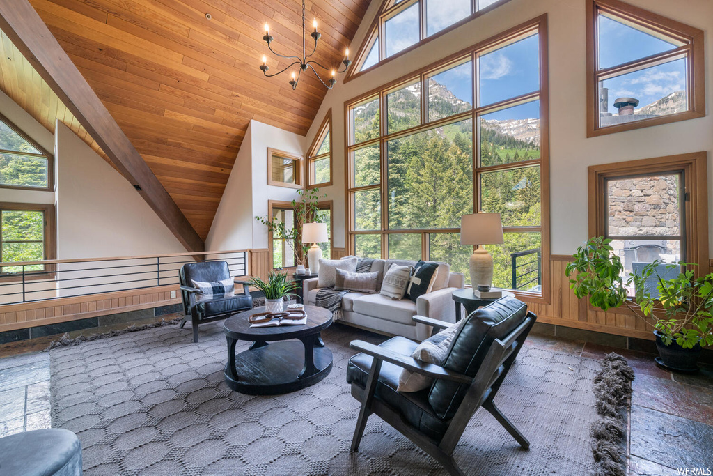 Living room with vaulted ceiling, a high ceiling, and natural light