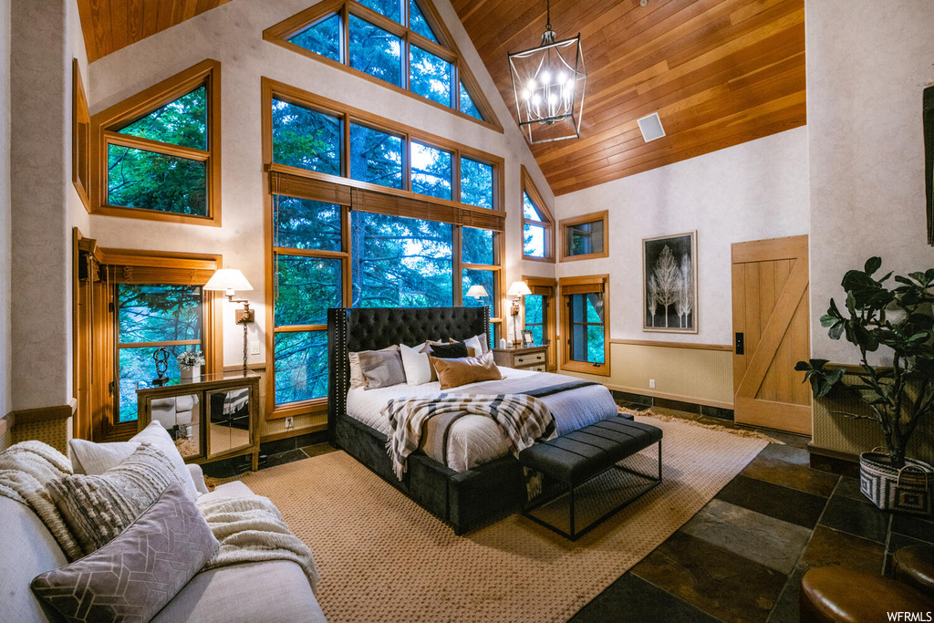Bedroom featuring multiple windows, a high ceiling, and lofted ceiling