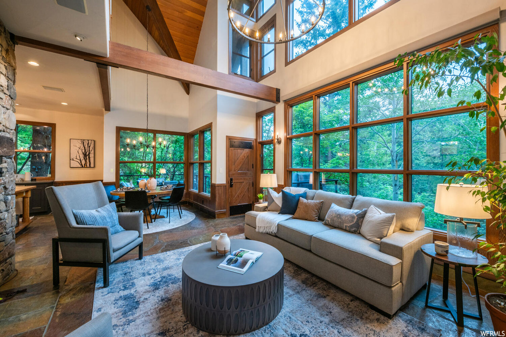 Living room with plenty of natural light, a high ceiling, and wood beam ceiling