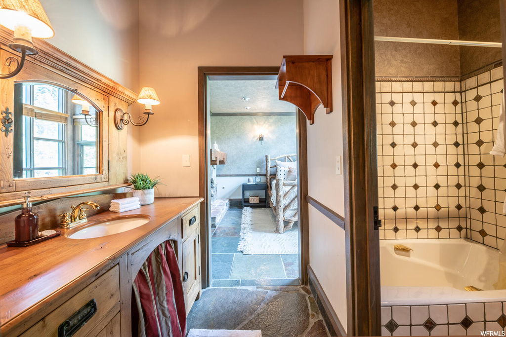 Bathroom with tile floors, natural light, mirror, vanity, and bathtub / shower combination