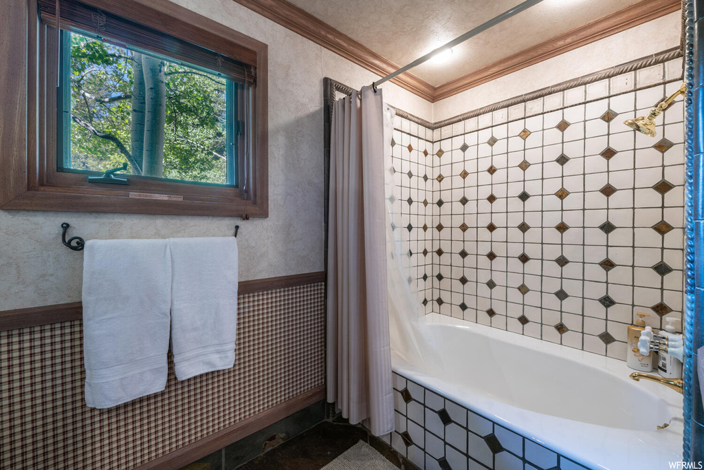 Bathroom with natural light, shower curtain, and tub / shower combination