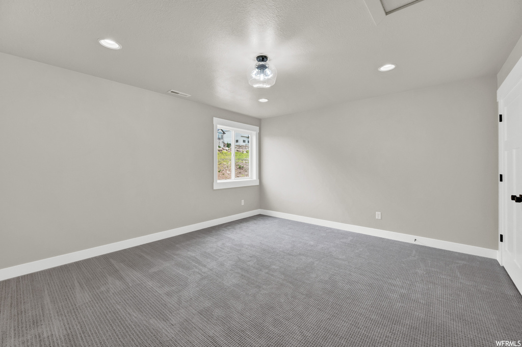 Empty room featuring carpet and natural light