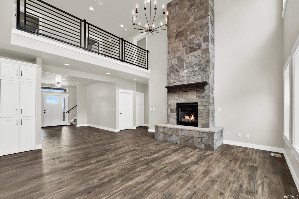 Living room with hardwood flooring, a fireplace, and a high ceiling