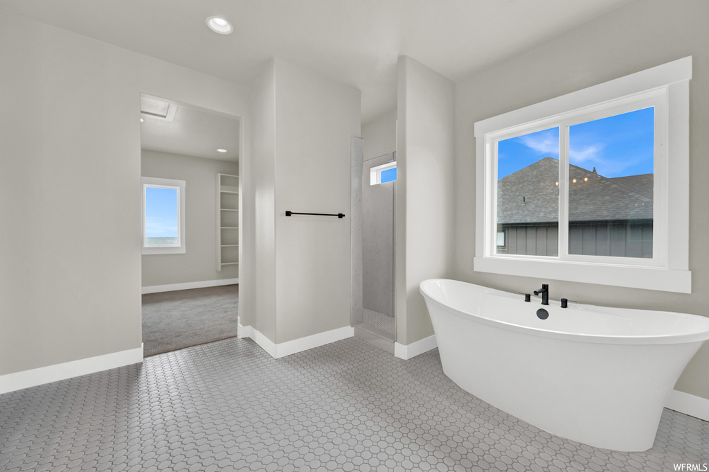 Bathroom featuring tile flooring, natural light, and a washtub
