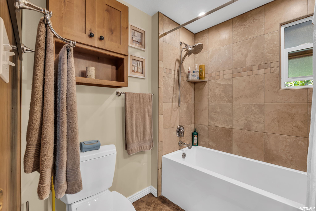 Bathroom with toilet and bath / shower combination