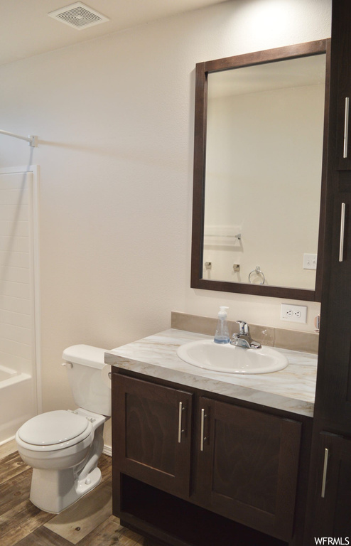 Full bathroom with shower / bathtub combination, wood-type flooring, vanity, and mirror