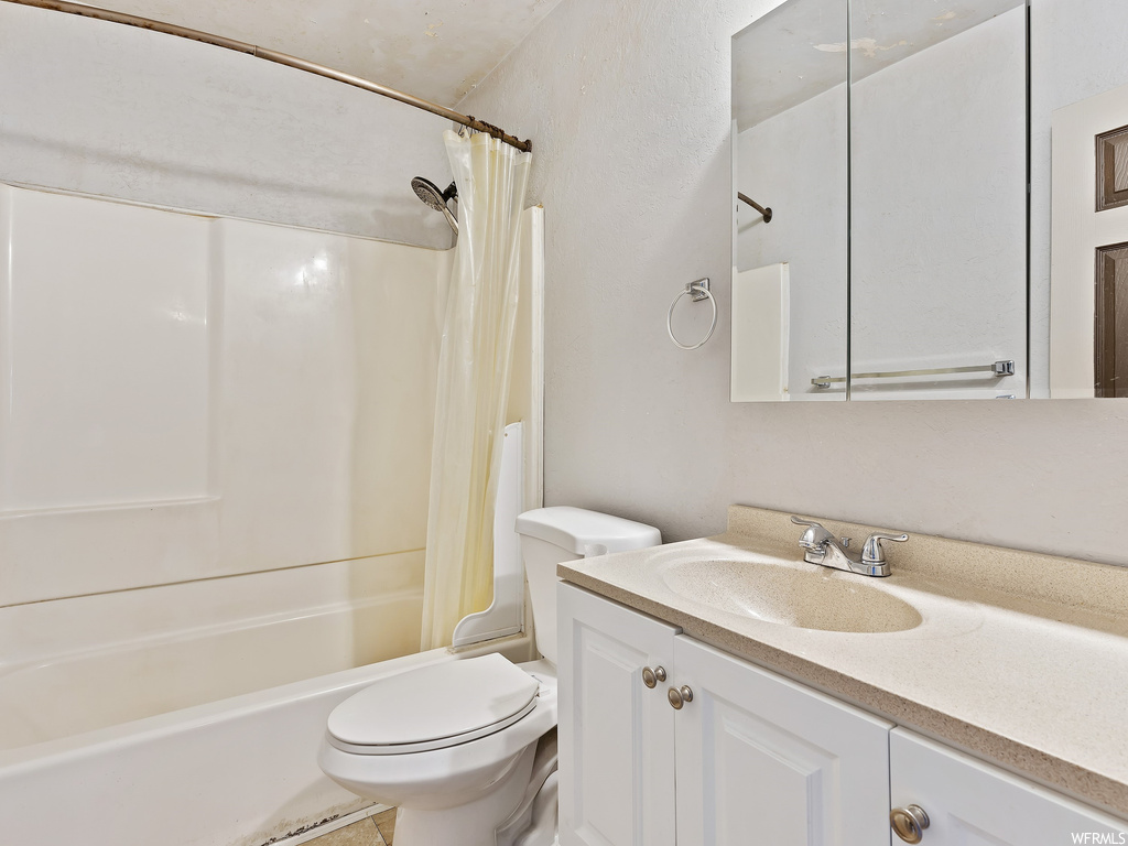 Full bathroom featuring mirror, toilet, shower curtain, vanity, and bathing tub / shower combination