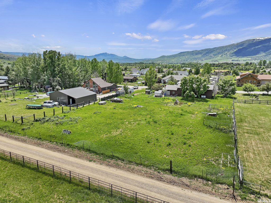 Property view of mountains featuring a lawn