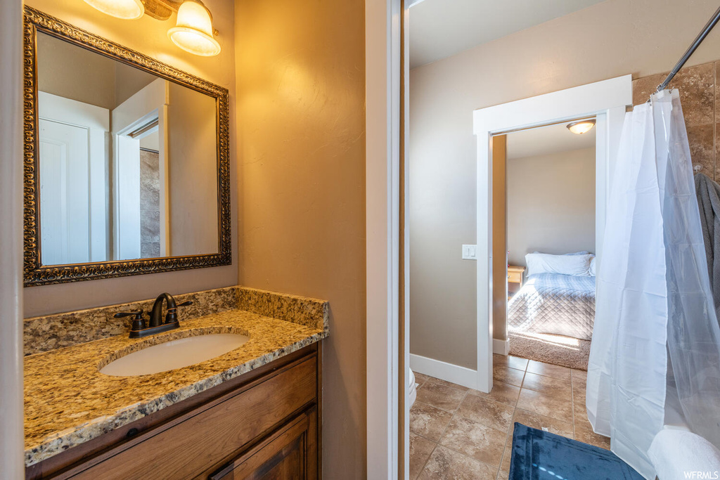 Bathroom featuring tile floors, shower curtain, mirror, and vanity