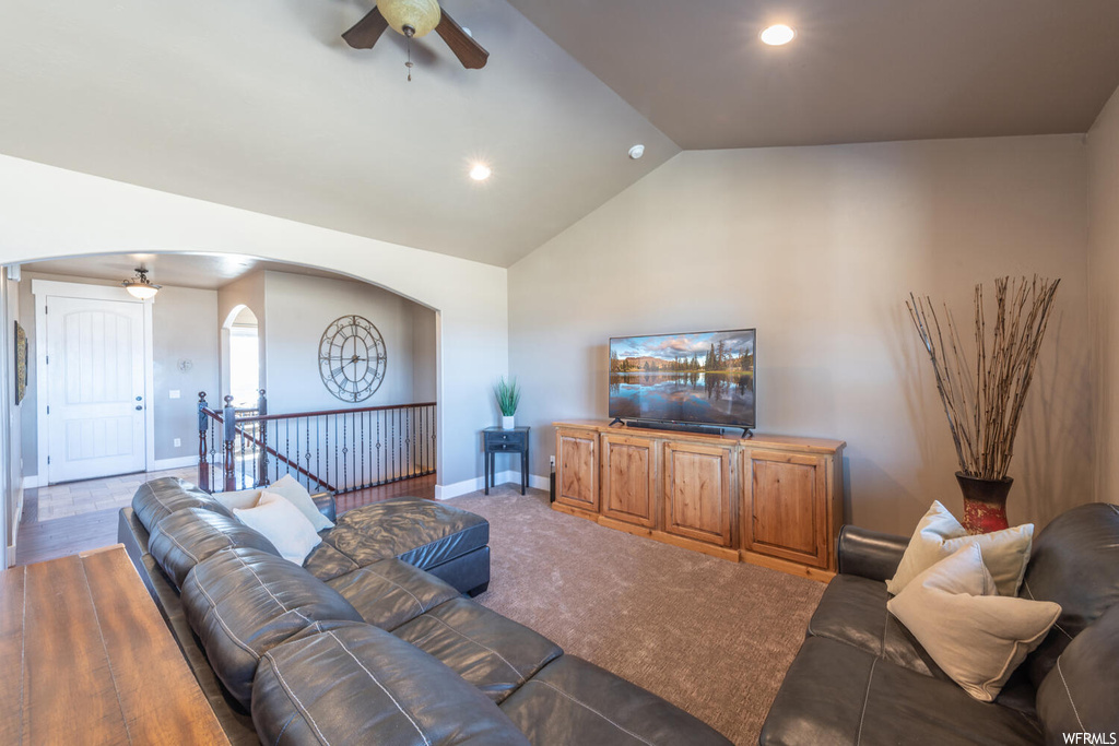 Living room featuring a ceiling fan, vaulted ceiling, and TV