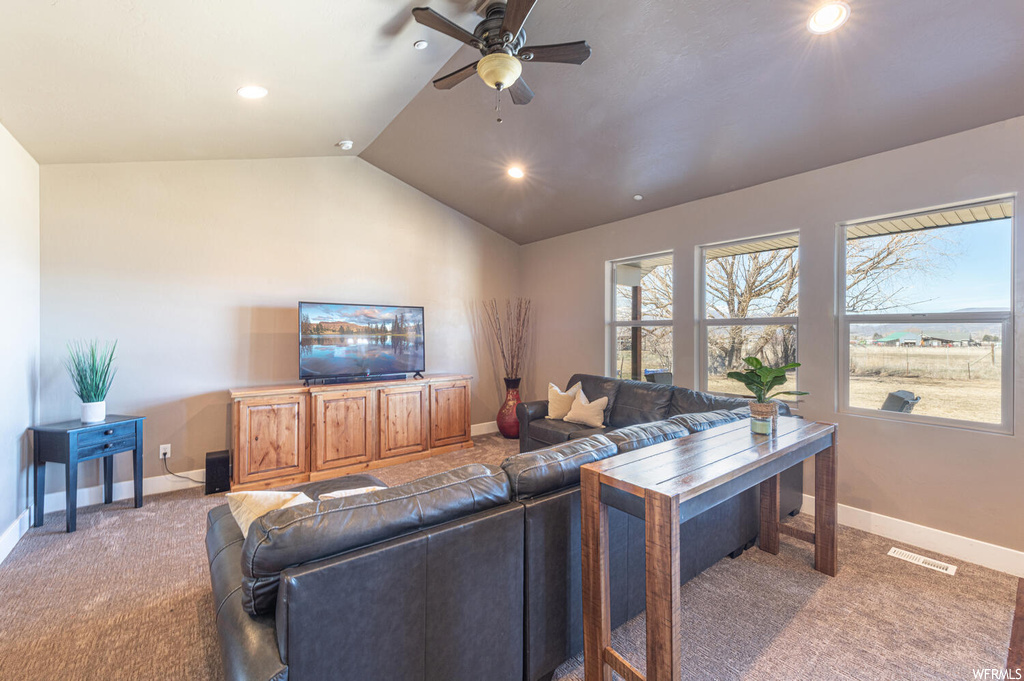 Carpeted living room featuring a ceiling fan, lofted ceiling, and TV