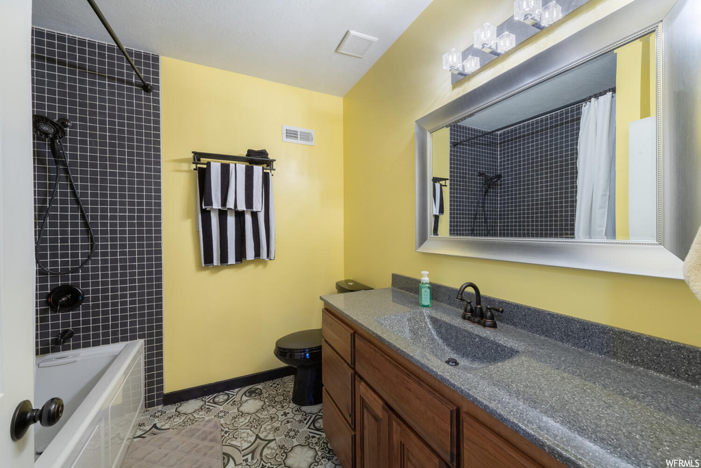 Full bathroom with shower / bathtub combination, mirror, vanity, toilet, and shower curtain