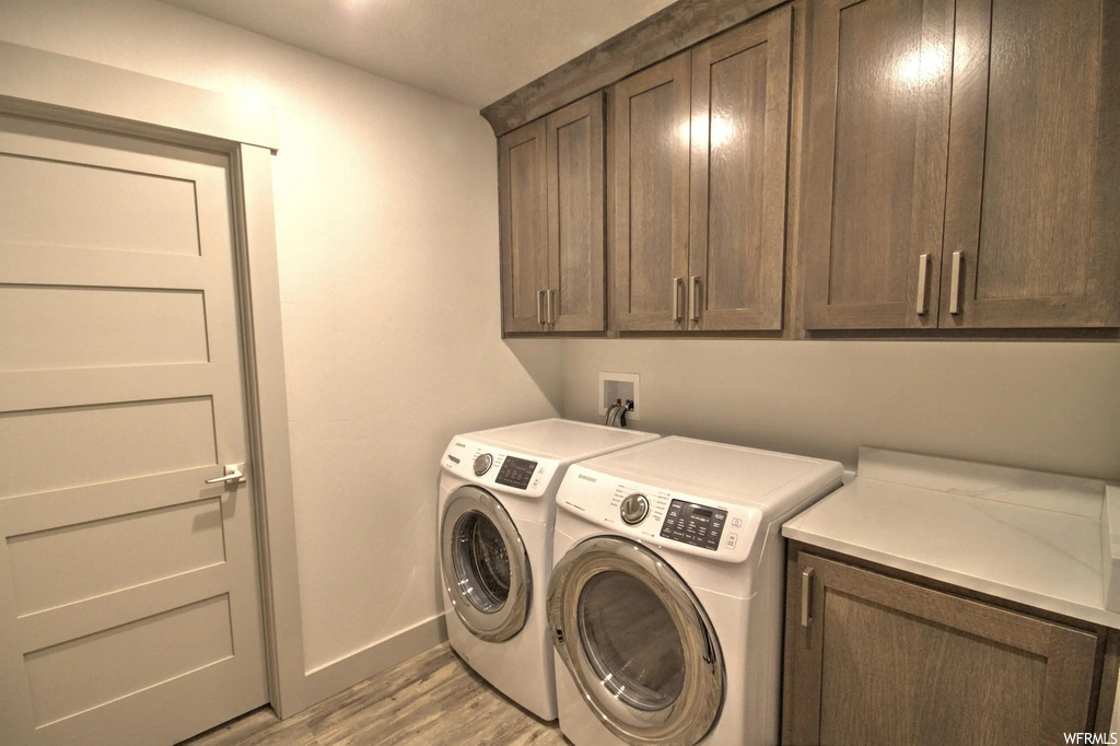 Clothes washing area featuring hardwood flooring and washer / dryer