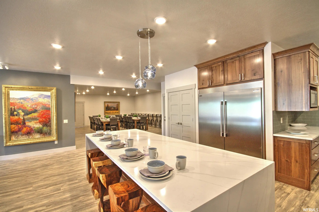 Kitchen featuring refrigerator, light countertops, and light parquet floors