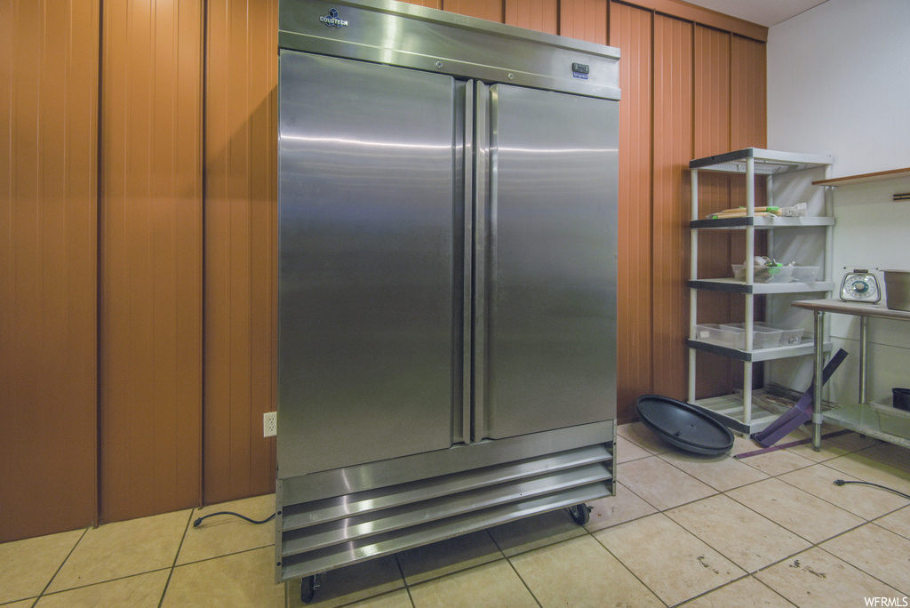 Kitchen featuring refrigerator and light flooring