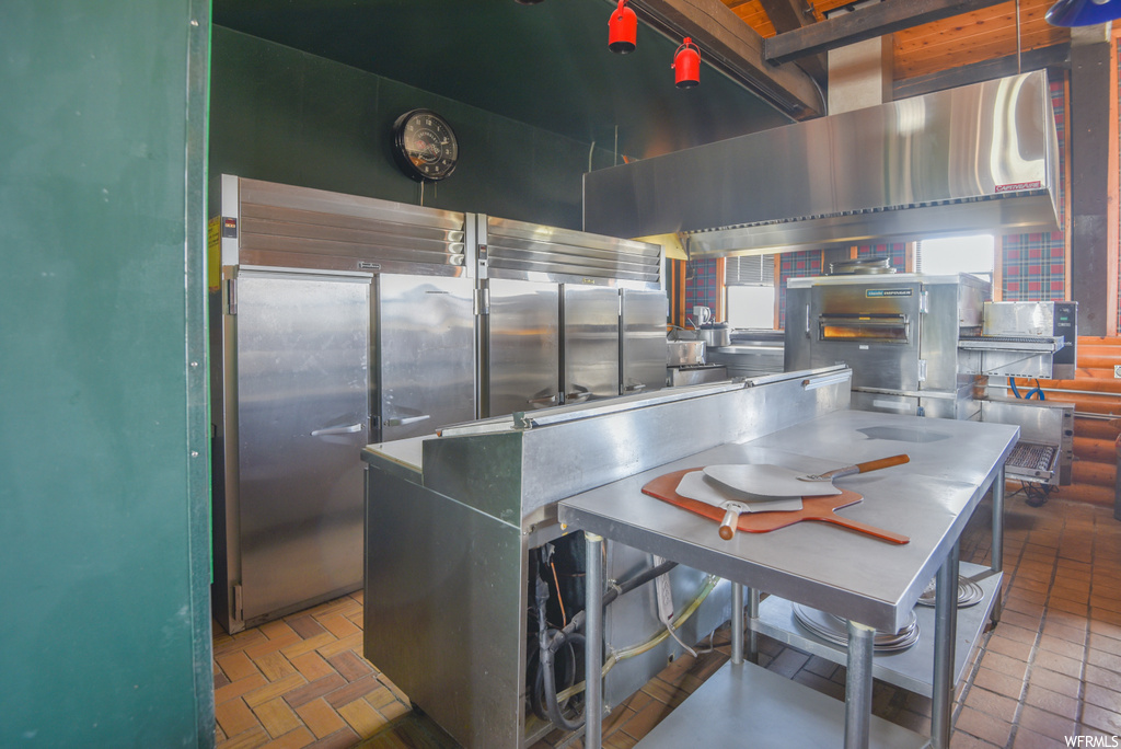 Kitchen with tile floors, stainless steel finishes, and dark countertops