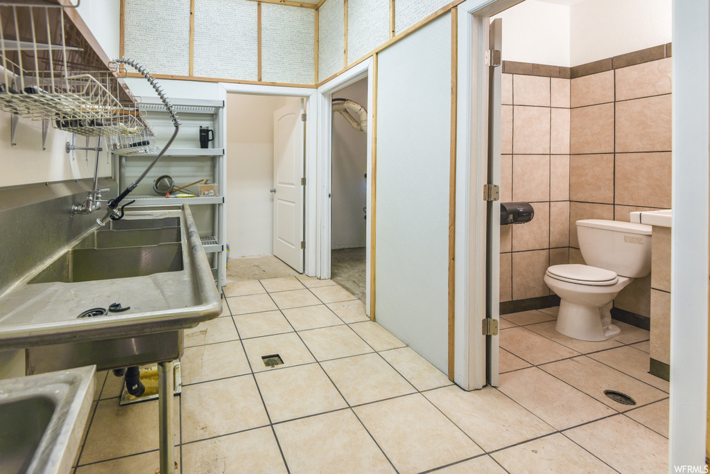 Half bath with tile flooring, toilet, and washbasin