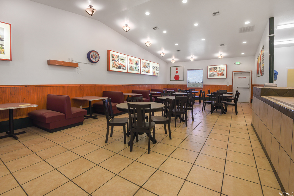 Dining space featuring vaulted ceiling and tile flooring