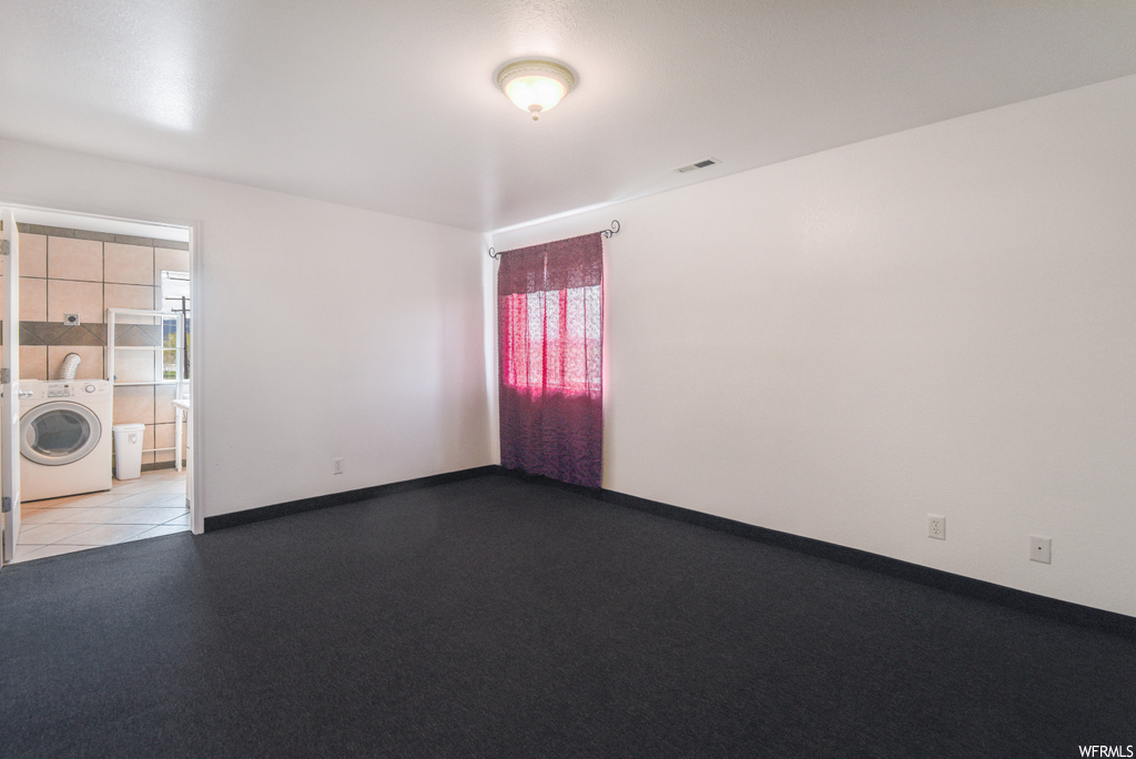 Carpeted spare room with washer / dryer