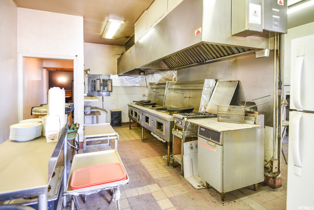 Kitchen featuring refrigerator, light tile floors, and light countertops