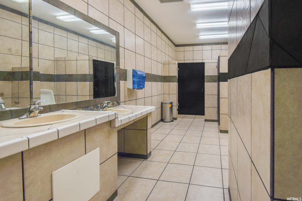 Bathroom featuring tile flooring, mirror, and double large vanity