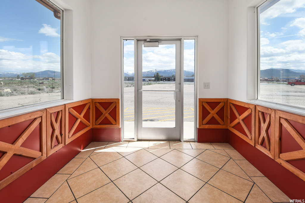 Doorway featuring tile floors and a healthy amount of sunlight