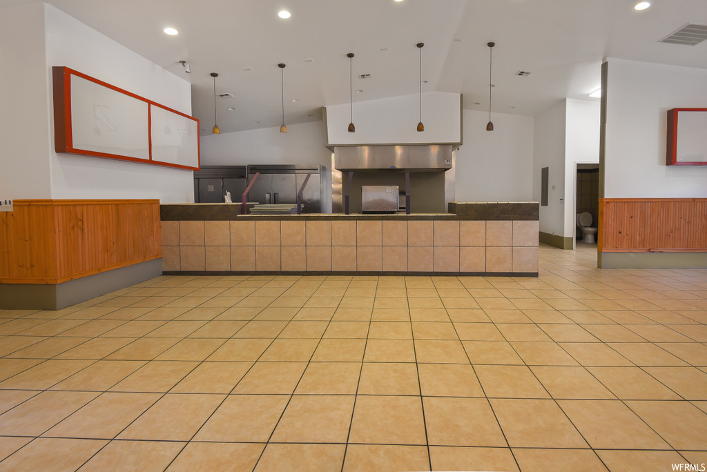 Kitchen featuring light tile floors, dark countertops, and pendant lighting
