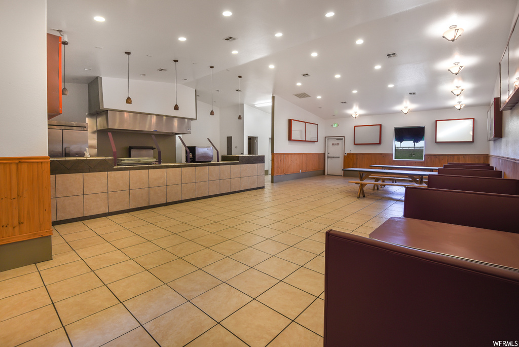 Kitchen with stainless steel finishes, light tile floors, and pendant lighting