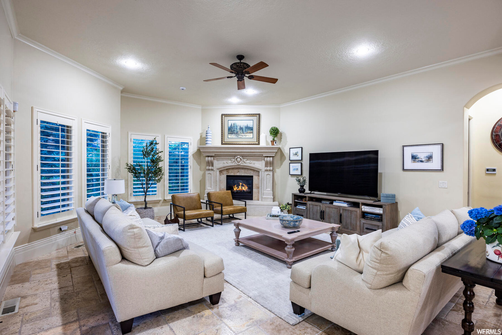 Living room with ornamental molding and ceiling fan