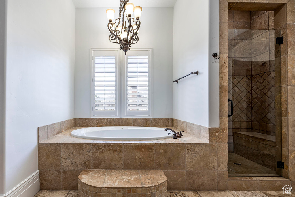 Bathroom featuring a notable chandelier, plus walk in shower, and tile flooring