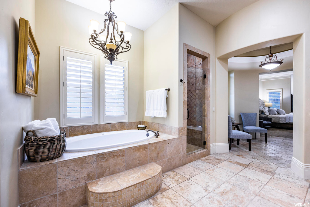 Bathroom with plus walk in shower, plenty of natural light, tile floors, and a notable chandelier