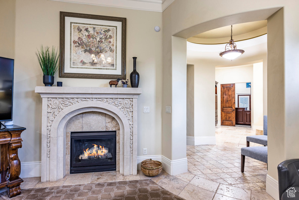 Interior space with light tile floors, a tray ceiling, and a fireplace