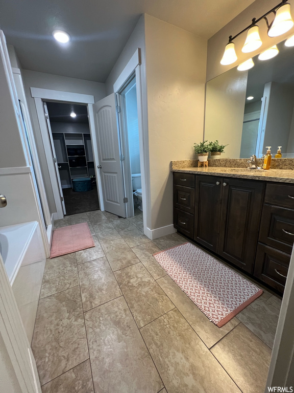 Bathroom with tile floors, a bath, mirror, and vanity
