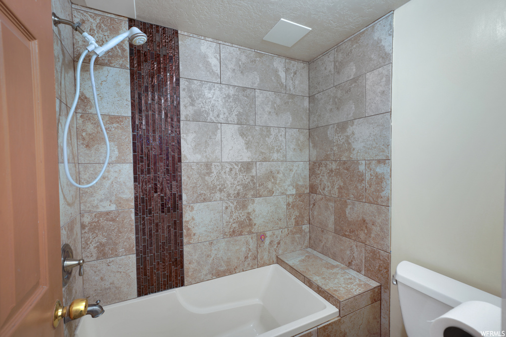 Bathroom with skylight, toilet, and shower / bathing tub combination